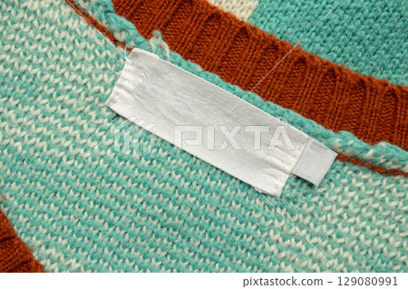 White blank laundry care clothes label on blue shirt fabric background White blank laundry care clothes label on blue shirt fabric background 129080991
