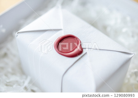 Wax seal stamp on white paper wrap packaging parcel box Wax seal stamp on white paper wrap packaging parcel box 129080993