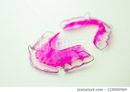 Pink acrylic dental retainer on white background Pink acrylic dental retainer on white background 129080994