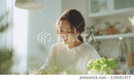 A Japanese woman standing in the kitchen 129081437