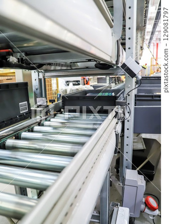 packing line in a logistics warehouse. conveyor belt in a modern production line packing line in a logistics warehouse. conveyor belt in a modern production line 129081797