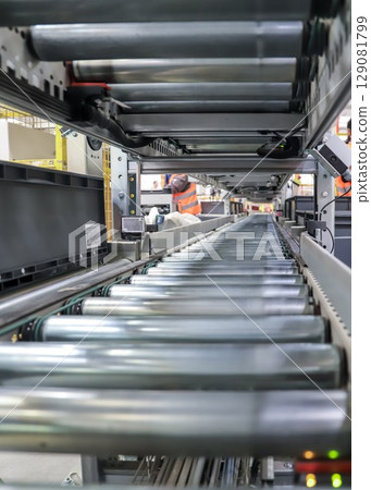 packing line in a logistics warehouse. conveyor belt in a modern production line packing line in a logistics warehouse. conveyor belt in a modern production line 129081799