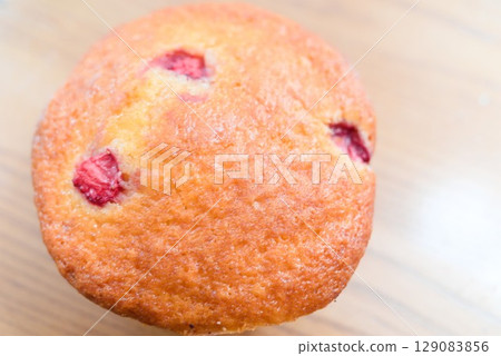 Freshly baked strawberry muffins - close-up of sweet and sour fruit desserts 129083856