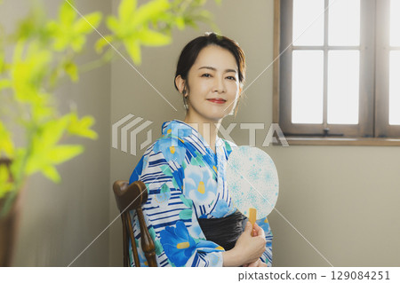 A woman in a yukata by the window A woman in a yukata by the window 129084251