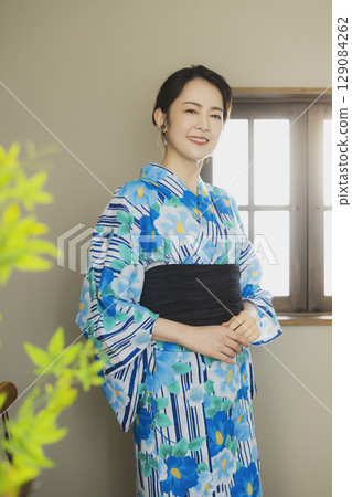 A woman in a yukata by the window 129084262