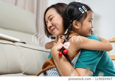 Emotional connection. Mother and daughter sharing a warm hug at home. 129084407