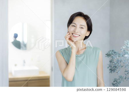 A woman in the bathroom doing skin care 129084598