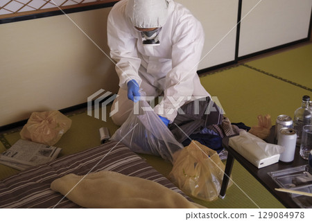 Workers in protective clothing at a garbage dump cleaning site 129084978