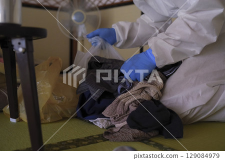 垃圾場清理現場身穿防護衣的工人 垃圾場清理現場身穿防護衣的工人 129084979