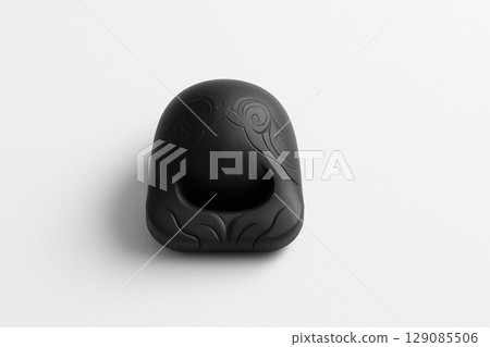 A simple black wooden fish placed on a white background A simple black wooden fish placed on a white background 129085506