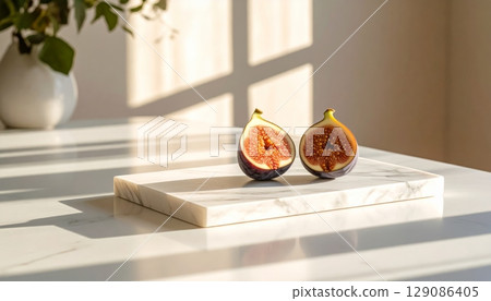 Two figs on marble counter with sunlight shadow 129086405