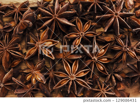 Badian or star anise on wooden background, spices for cooking Badian or star anise on wooden background, spices for cooking 129086431
