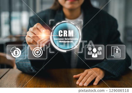 Businesswoman using CRM technology interface for effective customer relationship management in a modern office environment. 129086518