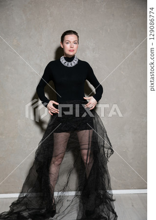 Portrait of a beautiful slender woman in a black evening dress 129086774