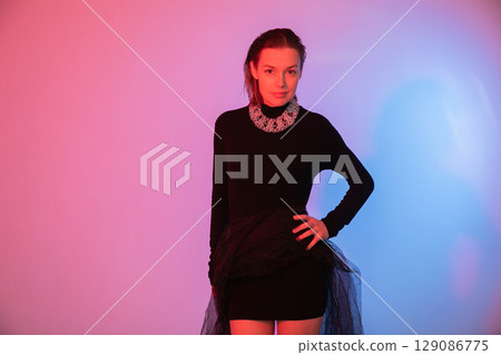 Portrait of a beautiful slender woman in a black evening dress Portrait of a beautiful slender woman in a black evening dress 129086775