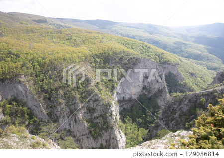 landscape on the mountains, green forest and blue sky with clouds landscape on the mountains, green forest and blue sky with clouds 129086814