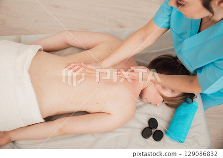 therapist doing medical spa back and body massage to woman therapist doing medical spa back and body massage to woman 129086832