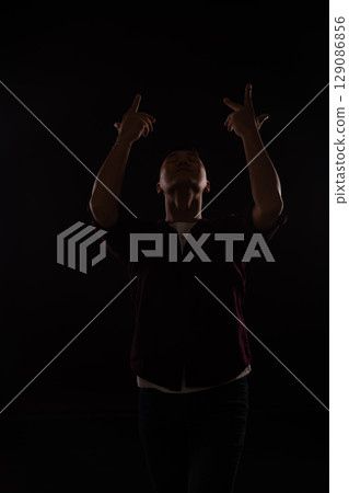 man in burgundy shirt dancing to music 129086856