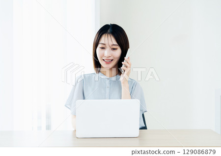 使用智能手機和電腦的女性 129086879