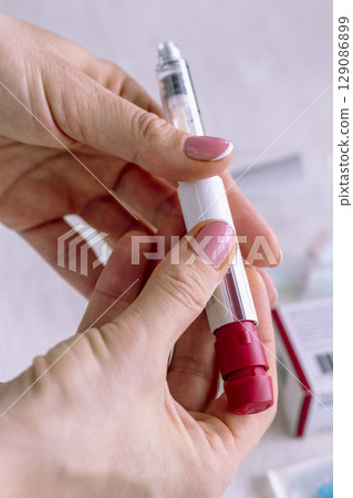 Close upshot of the woman preparing medicine for injection. Close upshot of the woman preparing medicine for injection. 129086899