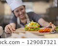 Smiling Young Asian Female Chef Making Sandwich 129087321