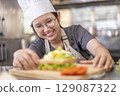 Smiling Young Asian Female Chef Making Sandwich 129087322