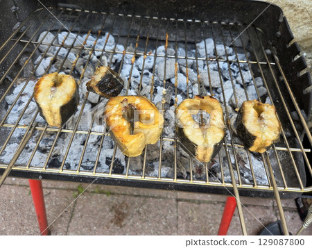 Grilled fish on charcoal barbecue for outdoor summer celebration 129087800