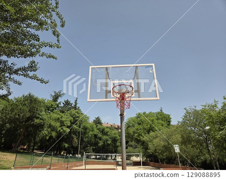 Outdoor basketball hoop in sunny park setting for recreational sports concept 129088895
