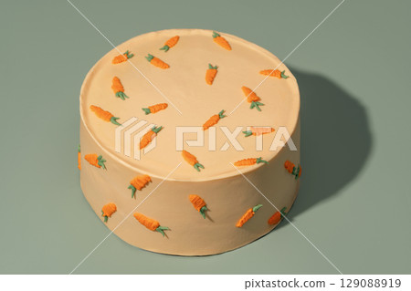 Round bento cake decorated with vibrant carrot designs on a smooth surface, showcasing a delightful dessert perfect for celebrations and special occasions with a charming aesthetic appeal 129088919
