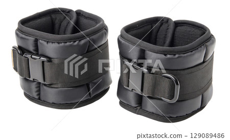 Black adjustable ankle weights for fitness training, featuring durable straps and soft padding for comfort, isolated on transparency background 129089486