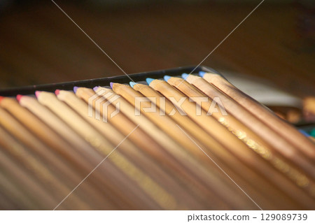 close up of colorful wooden pencils arranged in a case for artistic drawing 129089739