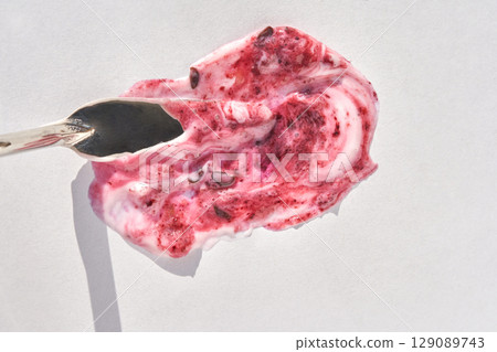 Spoonful of berry yogurt with mixed fruit on white background 129089743