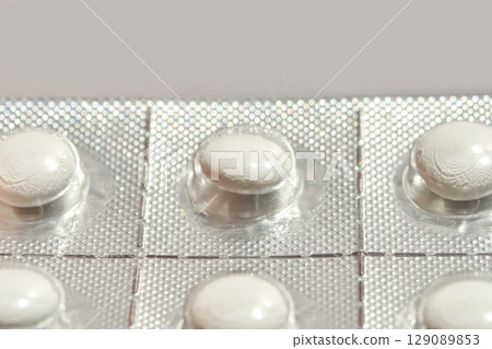 Blister pack with white pills in silver foil packaging for medicine Blister pack with white pills in silver foil packaging for medicine 129089853