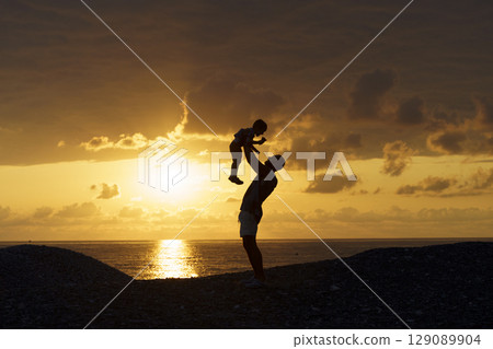 Father and Son Silhouettes at Sunset. Family Bonding Moment 129089904