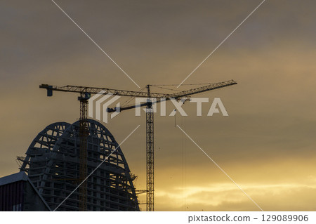 Construction Cranes at Sunset. Building the Future 129089906