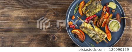 Grilled, fried fish on plate. 129090129