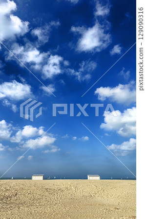 A Serene Beach Landscape Featuring a Clear Sky and Soft, Fluffy Clouds Above the Shoreline A Serene Beach Landscape Featuring a Clear Sky and Soft, Fluffy Clouds Above the Shoreline 129090316