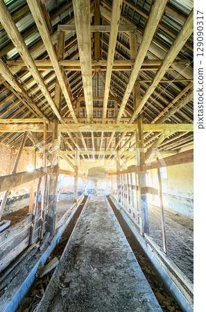 The interior space of an Abandoned Barn showcasing its Exposed Wooden Beams and rustic charm 129090317