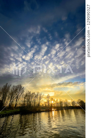 The Serene Sunset Over Calm Waters Accompanied by Dramatic and Beautiful Skies Above The Serene Sunset Over Calm Waters Accompanied by Dramatic and Beautiful Skies Above 129090327