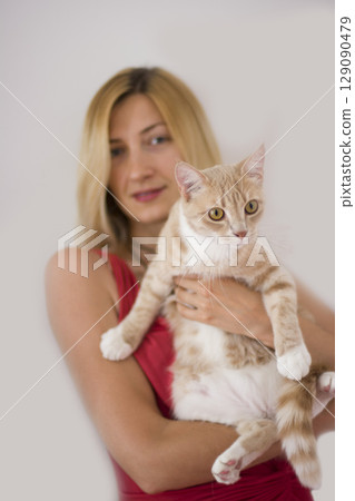 Beautiful young blonde girl holging her ginger cat. Bestfriends 129090479