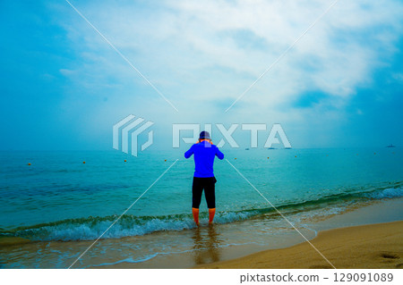 Asian man entering the sea 129091089