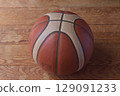 A well-worn basketball on the floor 129091233