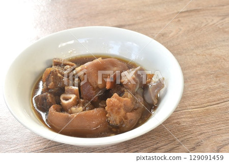 boiled braised salty pork leg in Chinese herb brown soup in bowl  129091459
