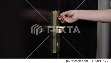 Close up of female hand open hotel room door with electronic card key. Protection and security system concept. Close up of female hand open hotel room door with electronic card key. Protection and security system concept. 129091577