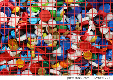 A Vibrant and Colorful Collection of Plastic Bottle Caps Arranged in a Grid Format 129091775