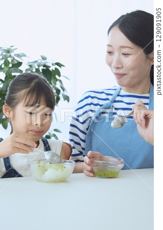 夏日時光,一位母親看著女兒吃刨冰 夏日時光,一位母親看著女兒吃刨冰 129091905