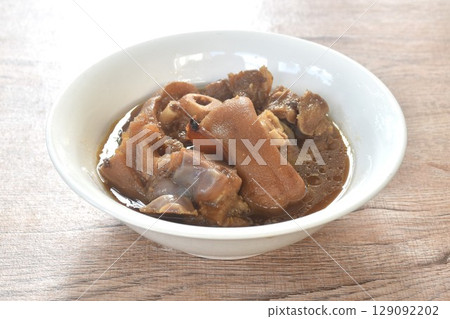 boiled braised salty pork leg in Chinese herb brown soup in bowl  129092202