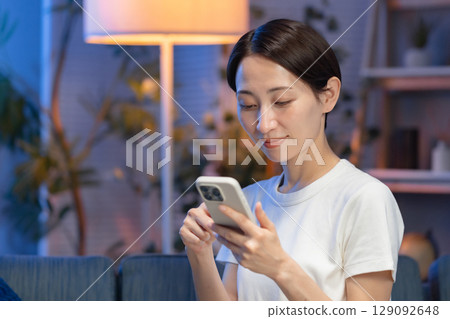 Woman with smartphone at night Woman with smartphone at night 129092648