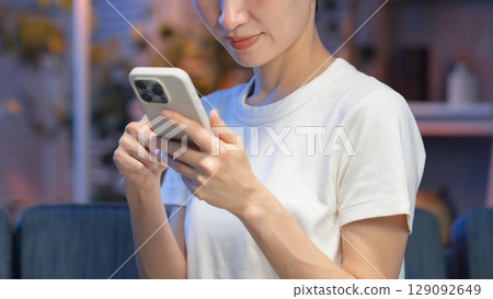 Woman with smartphone at night Woman with smartphone at night 129092649