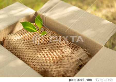 Green leaf on eco friendly brown paper honeycomb wrap for product packaging parcel carton box 129092790